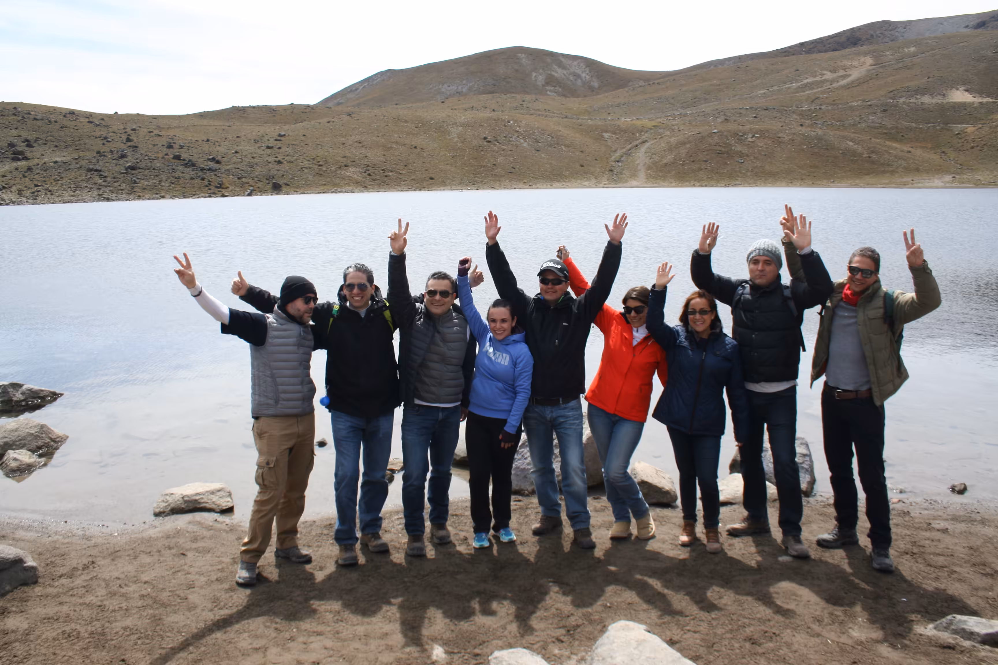Equipo de trabajo celebrando junto a un lago